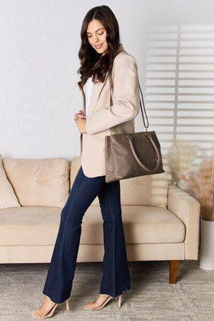 a woman standing in front of a couch holding a purse