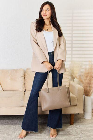 a woman standing in front of a couch holding a purse
