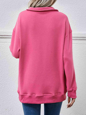 a woman wearing a pink sweatshirt and jeans