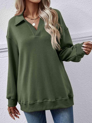 a woman wearing a green sweater and jeans
