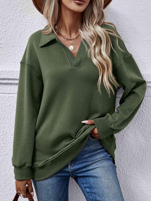 a woman wearing a green sweater and hat