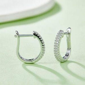 a pair of diamond hoop earrings on a table