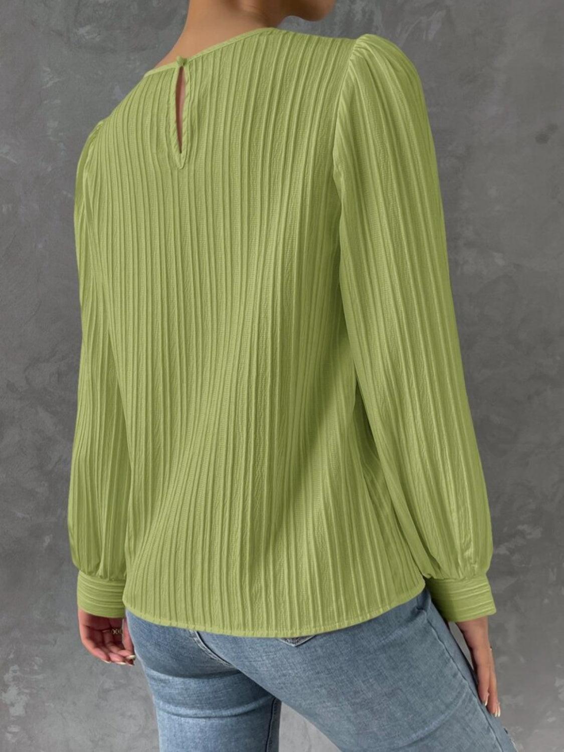 a woman wearing a green sweater and jeans