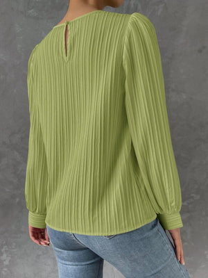 a woman wearing a green sweater and jeans
