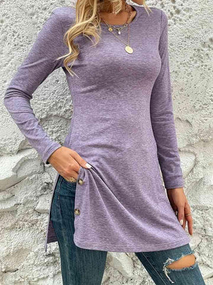 a woman wearing a purple shirt and ripped jeans