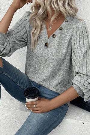 a woman wearing a gray sweater and jeans