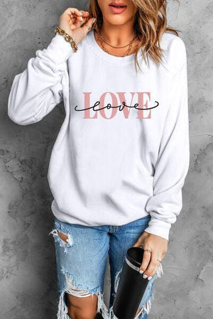 a woman wearing a white sweatshirt with the word love on it