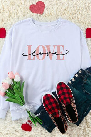 a white shirt with the word love on it next to a pair of jeans and