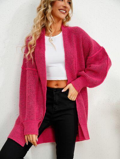 a woman wearing a pink sweater and black pants