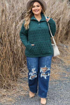 a woman wearing a green sweater and ripped jeans