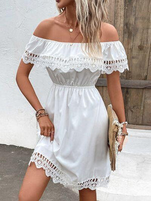 a woman wearing a white off the shoulder dress