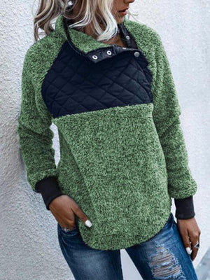 a woman wearing a green and black sweater