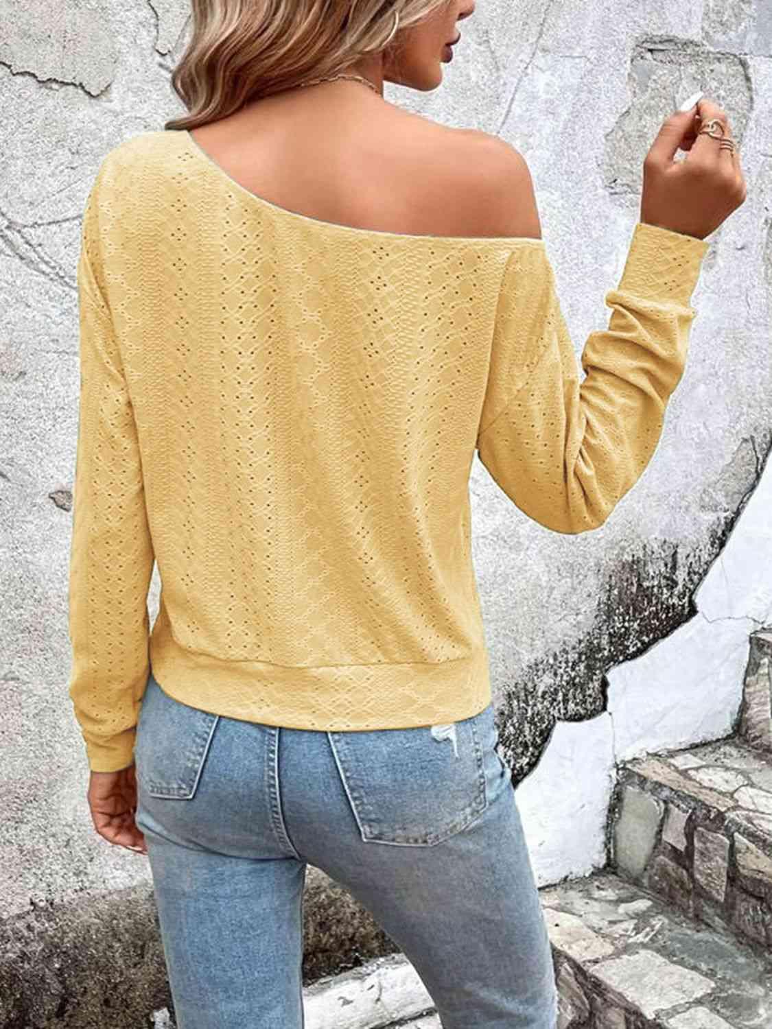 a woman wearing a yellow sweater and jeans