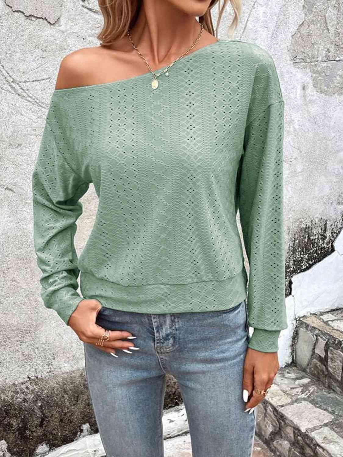 a woman wearing a green sweater and jeans