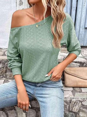 a woman wearing a green sweater and jeans