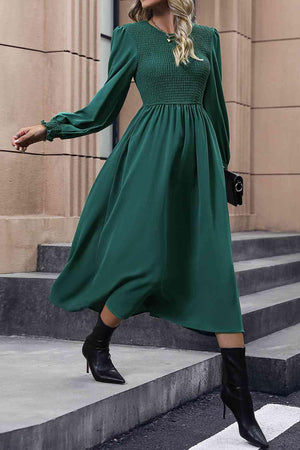 a woman wearing a green dress and black boots