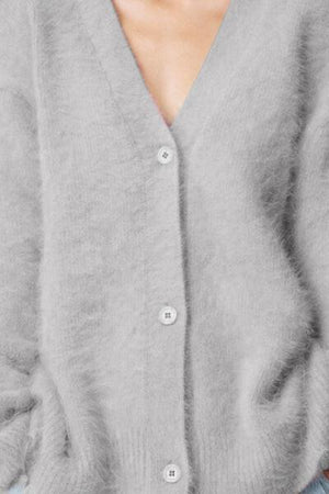 a close up of a person wearing a gray cardigan