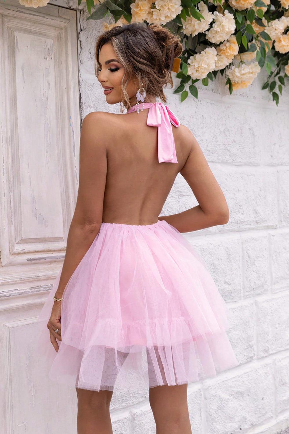 a woman wearing a pink dress with a bow on the back