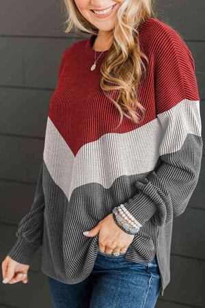 a woman wearing a red and grey striped sweater