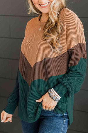 a woman wearing a green and brown sweater
