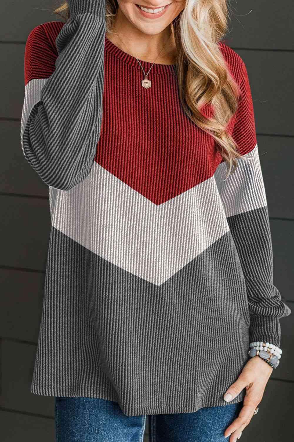 a woman wearing a red and grey sweater