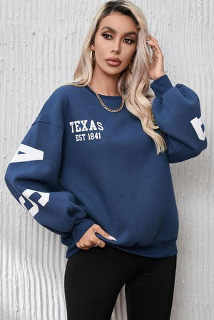 a woman wearing a texas sweatshirt and leggings