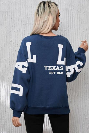 a woman wearing a blue sweatshirt with white letters on it