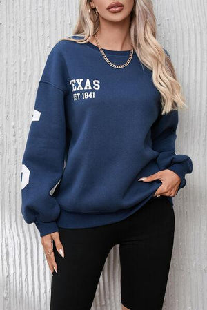a woman wearing a texas sweatshirt and black leggings