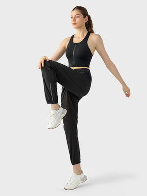 a woman in a black sports bra top and black pants