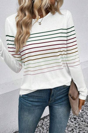 a woman wearing a white striped sweater and jeans