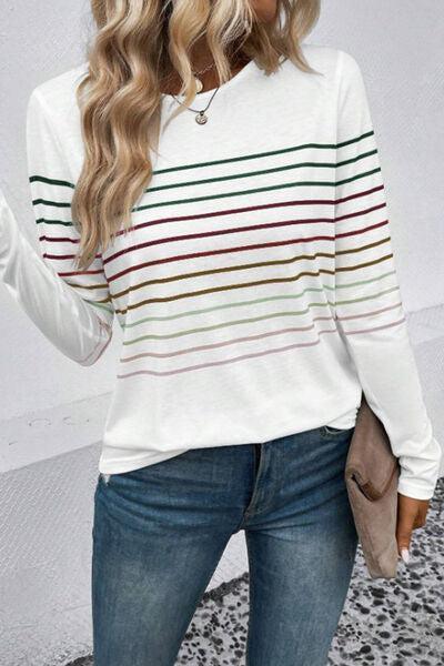 a woman wearing a white striped sweater and jeans