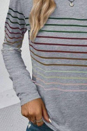 a woman wearing a grey striped shirt and jeans
