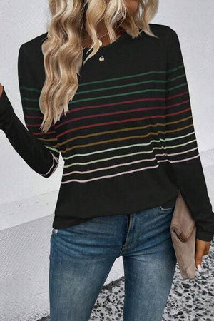 a woman wearing a black striped sweater and jeans