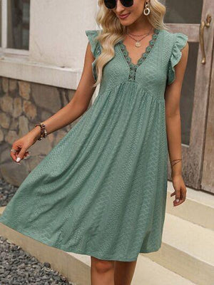 a woman wearing a green dress and sunglasses