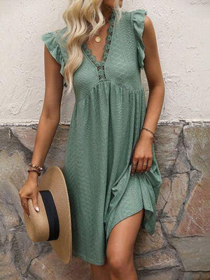 a woman wearing a green dress and hat