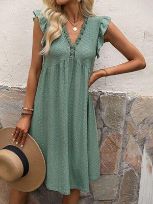 a woman wearing a green dress and hat