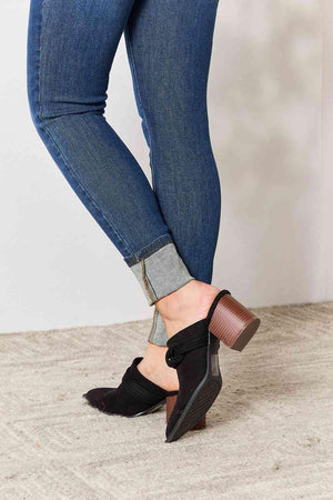 a close up of a woman's legs wearing jeans and heels