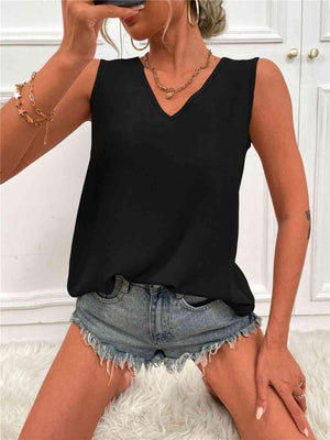 a woman wearing a black top and denim shorts