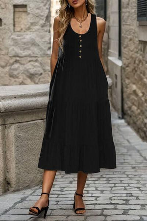 a woman in a black dress standing on a cobblestone street
