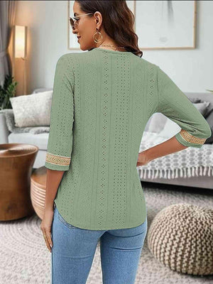 a woman standing in a living room wearing a green sweater