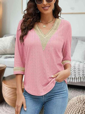 a woman wearing a pink top and jeans