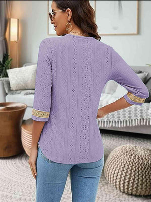 a woman wearing a purple sweater and jeans