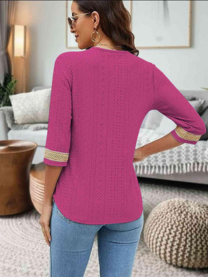 a woman standing in a living room wearing a pink top