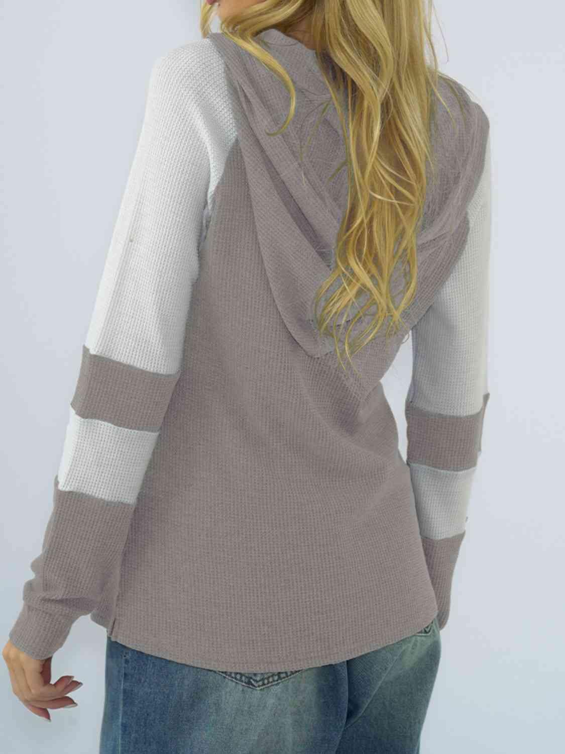 a woman with long blonde hair wearing a sweater and jeans