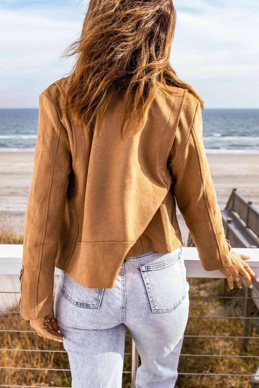 a woman standing on a balcony looking out at the ocean