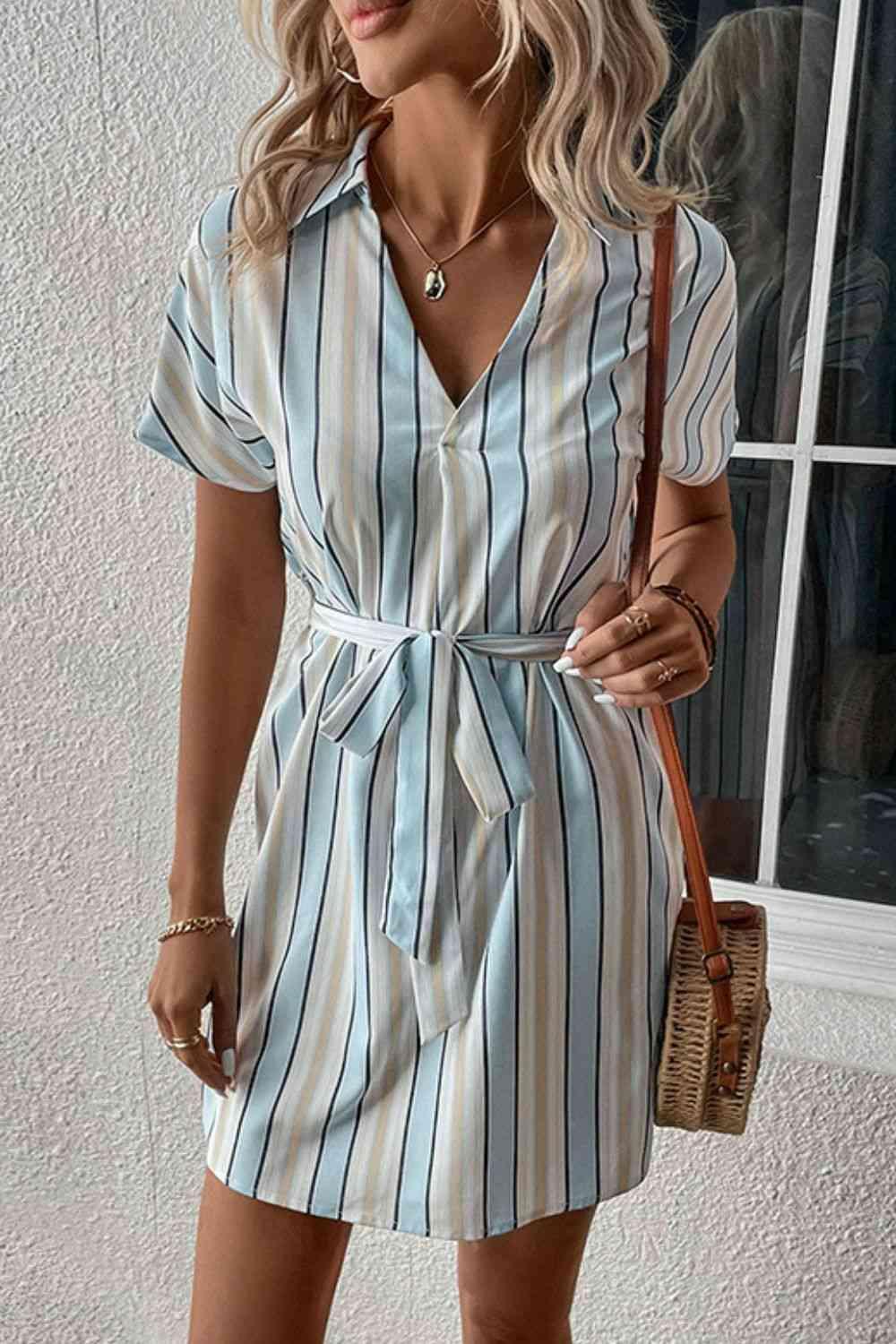 a woman wearing a blue and white striped dress
