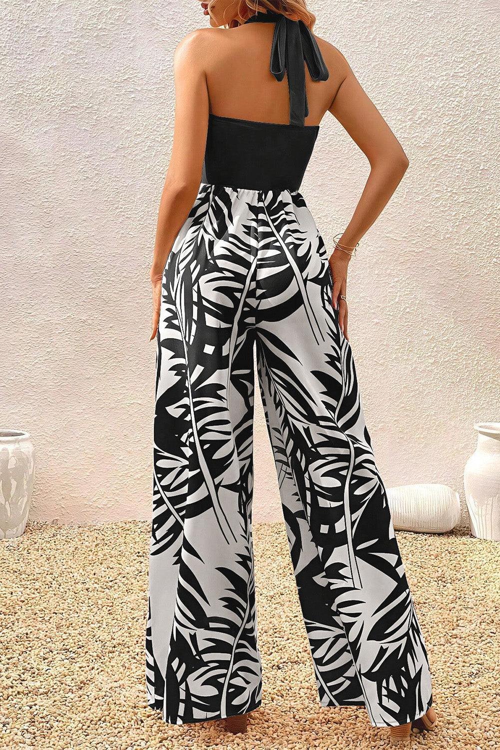a woman wearing a black and white tropical print jumpsuit