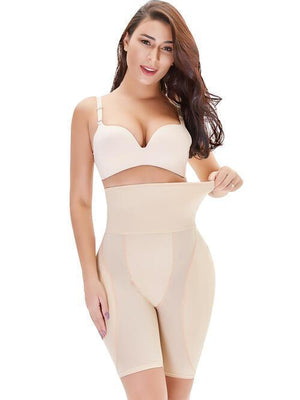 a woman in a beige bodysuit posing for the camera