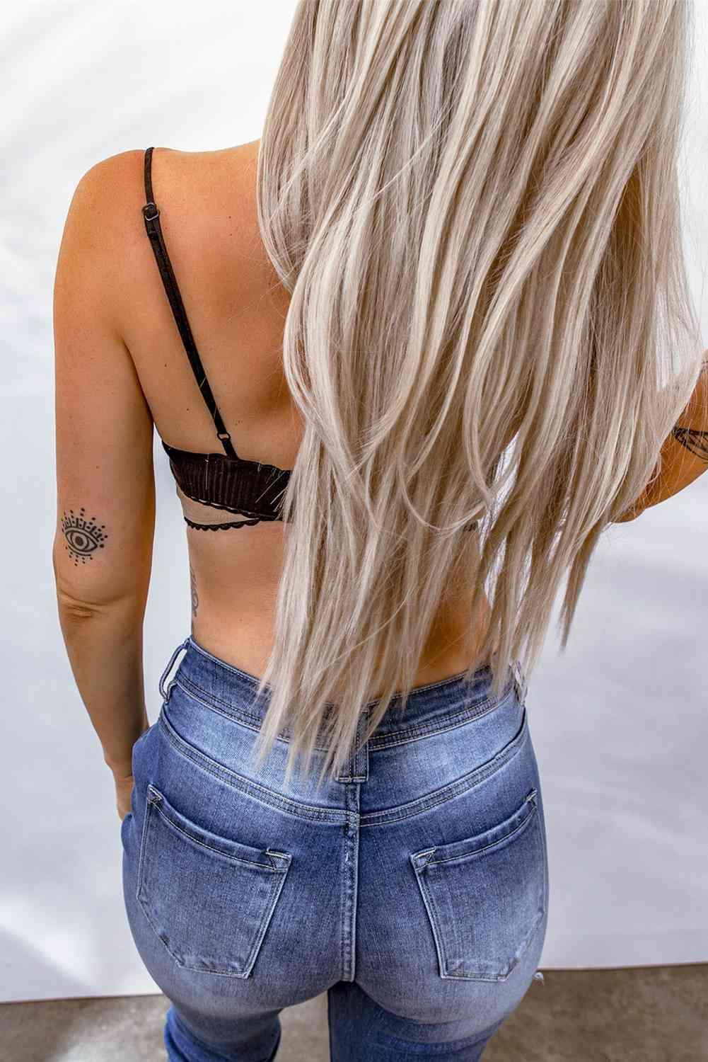 a woman with blonde hair wearing jeans and a bra