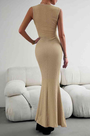 a woman in a tan dress standing in front of a white couch